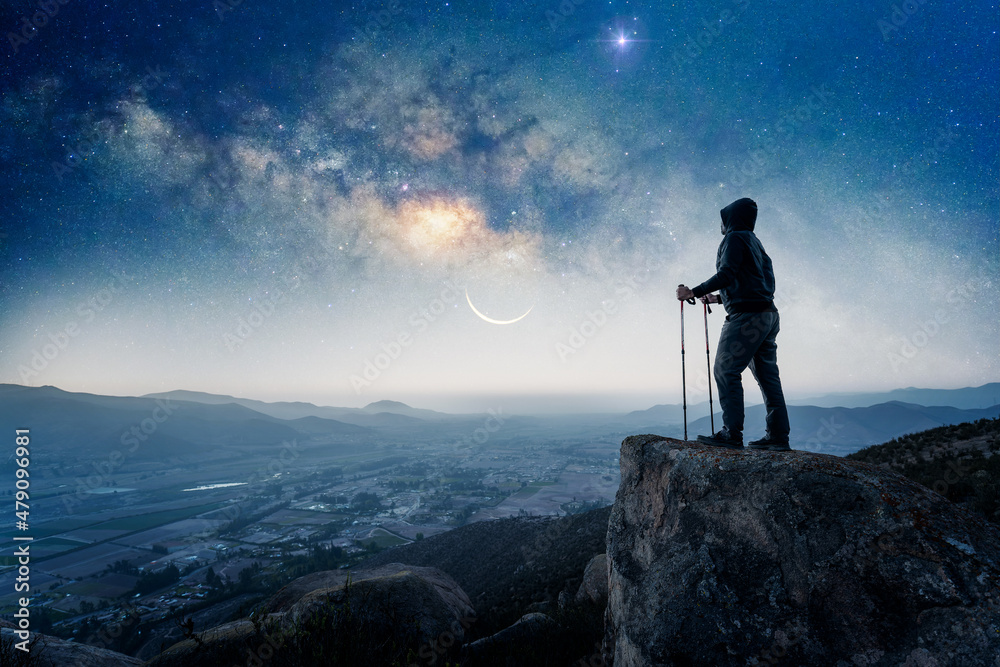 silhouette of a hiker on the top of the mountain staring the Milky Way and the Moon over Valle del Elqui silhouette of a hiker on the top of the mountain staring the Milky Way and the Moon over Valle del Elqui