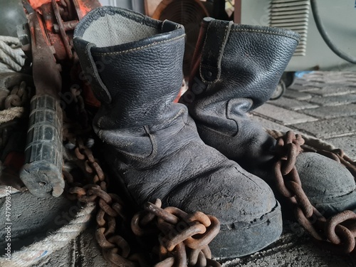 safety shoes wrapped in chain in workshop, construction worker concept
