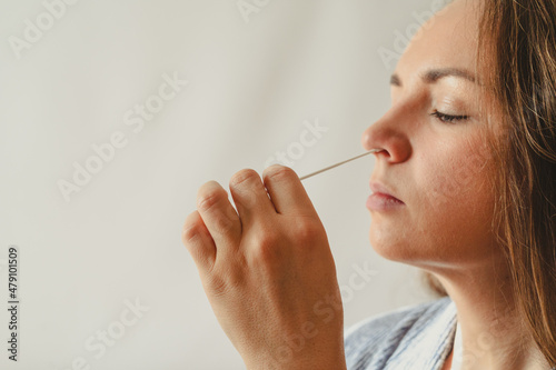 Young white woman doing at home antigen nose swab for covid 19 