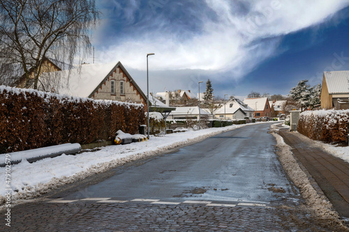 A road with houses in a Danish town on a snowy winter day