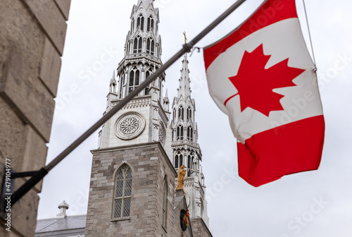 Canadian flag on building in front of the Notre-Dame Cathedral Basilica in Ottawa, Canada