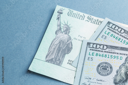 A tax return stimulus check with some American hundred dollar bills