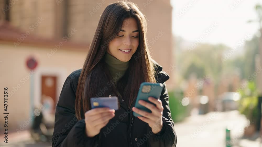 Young hispanic woman using smartphone and credit card at street Young hispanic woman using smartphone and credit card at street