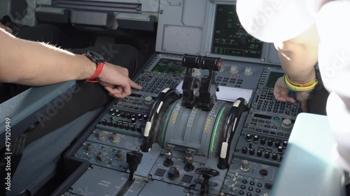 Close up shot of flight crew operating commercial aircraft, shot inside cockpit flight deck control panel, airplane captain and co-pilot discussing about the flying route, airplane system technician, 