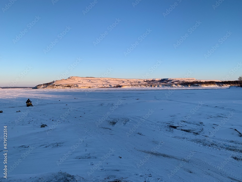 view of the snowy hills lit in the setting sun in winter view of the snowy hills lit in the setting sun in winter