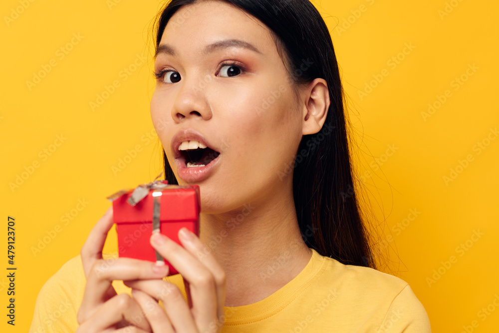 Portrait Asian beautiful young woman holding a gift box in his hands posing isolated background unaltered Portrait Asian beautiful young woman holding a gift box in his hands posing isolated background unaltered