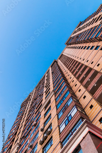 Worm's-eye view of high-rise apartment building on the background of clear sky, Tyumen, Russia 