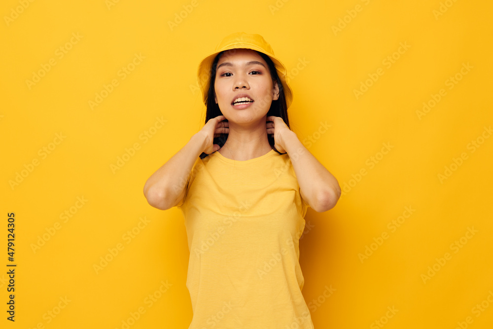 Charming young Asian woman wearing a yellow hat posing emotions yellow background unaltered Charming young Asian woman wearing a yellow hat posing emotions yellow background unaltered