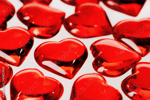 St Valentines day full frame background. Many red glass hearts closeup. Love or wedding concept. Selective focus