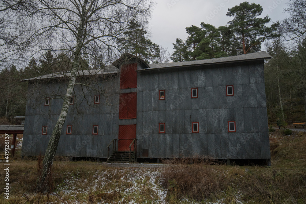 Old corrugated sheet metal house for mill storage in shadow a winter day in Stockholm Old corrugated sheet metal house for mill storage in shadow a winter day in Stockholm