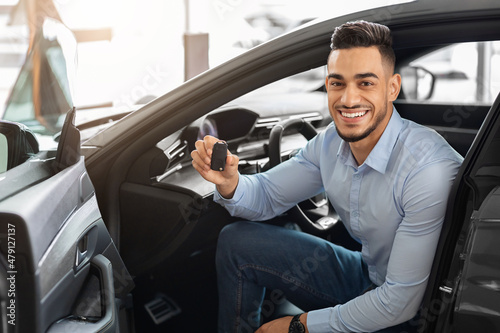Handsome arab man customer sitting in auto and holding key © Prostock-studio