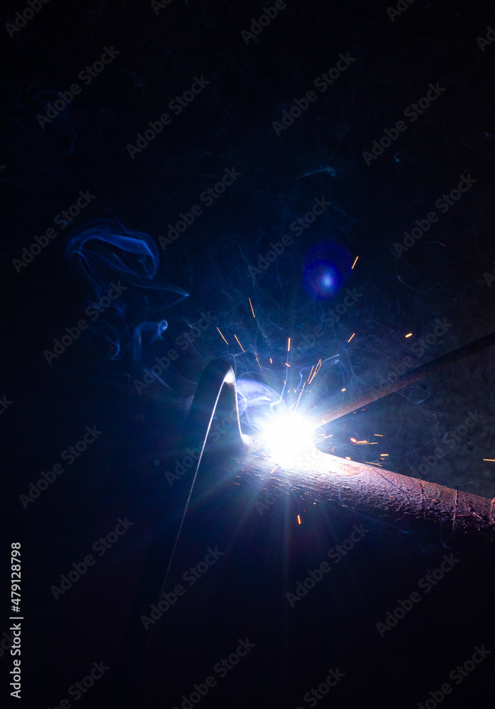 Welding of metal structures. Welding flame with sparks.
