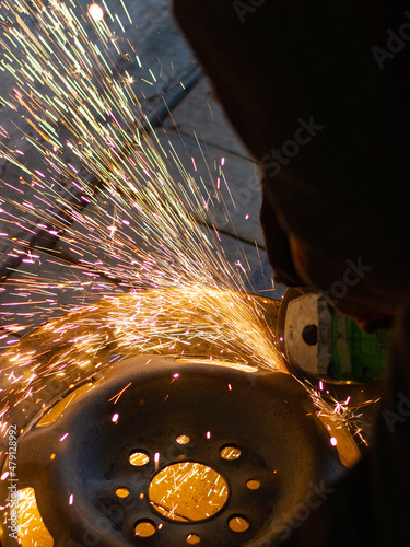 Spark grinder. Hot white sparks when cutting steel material. Industrial worker cutting metal with a grinder. Lots of glowing sparks