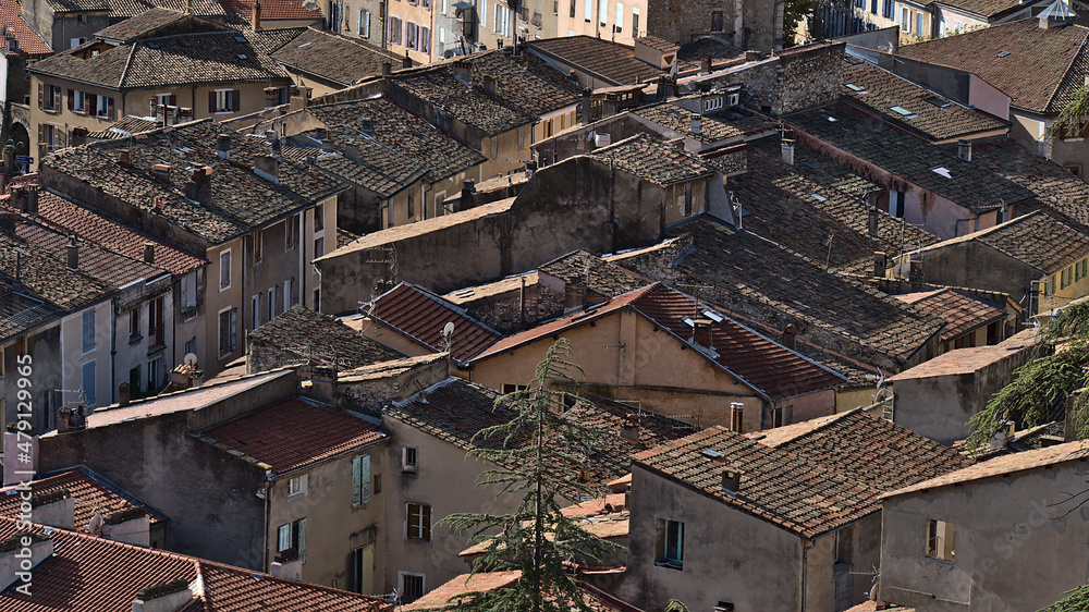 Aerial close-up view of the dense historic center of town Sisteron in Provence, France on sunny day with the rooftops of old buildings in autumn.