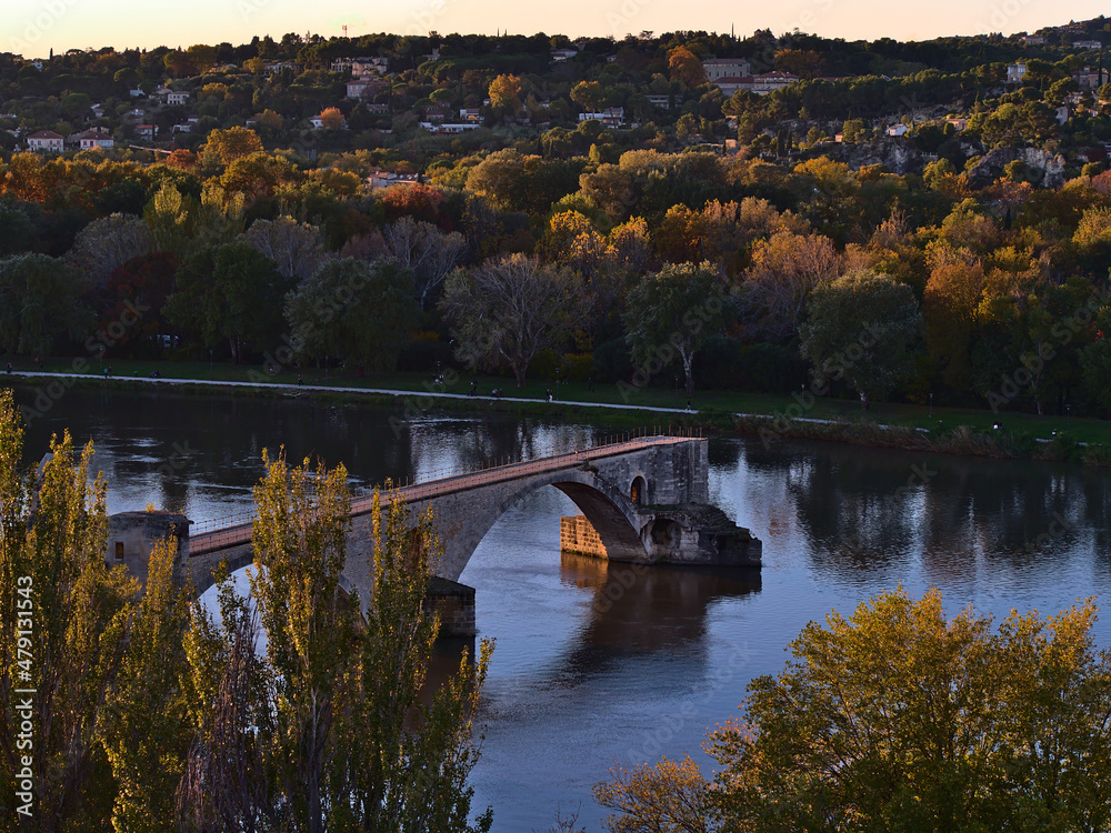 High angle view of bridge Pont Saint-Benezet with Rhone river surrounded by colorful trees in autumn viewed from Rocher des Doms in Avignon, France.