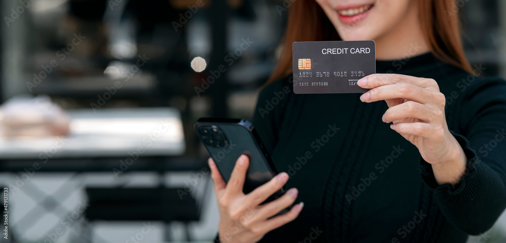 Asian woman holding and presenting the credit card for online shopping, technology money wallet and online payment concept, credit card mockup.