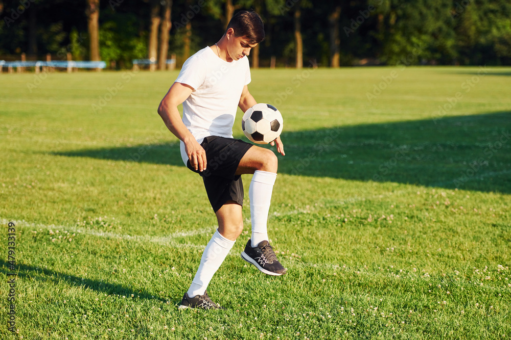 Sunny daytime. Young soccer player have training on the sportive field Sunny daytime. Young soccer player have training on the sportive field