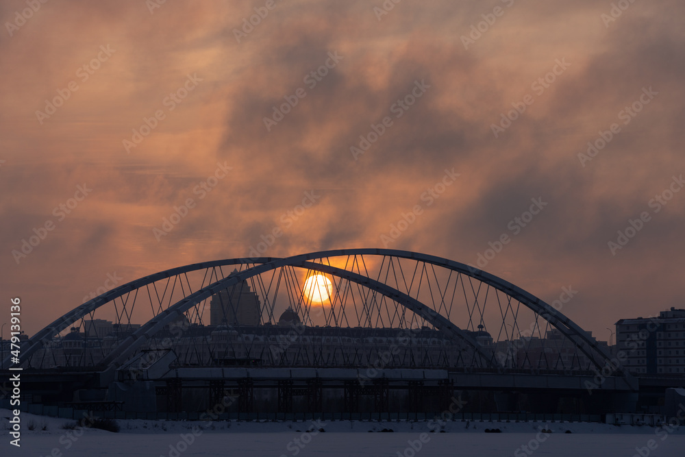Sunset over the bridge across Ishim river in Nur-Sultan, Kazakhstan.