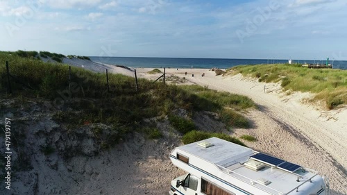 Trailer Caravanning at the beach. Aerial view of RV car with trailer caravan, parked alone at the dune, with epic ocean view. Family or friend vacation on the camping. 