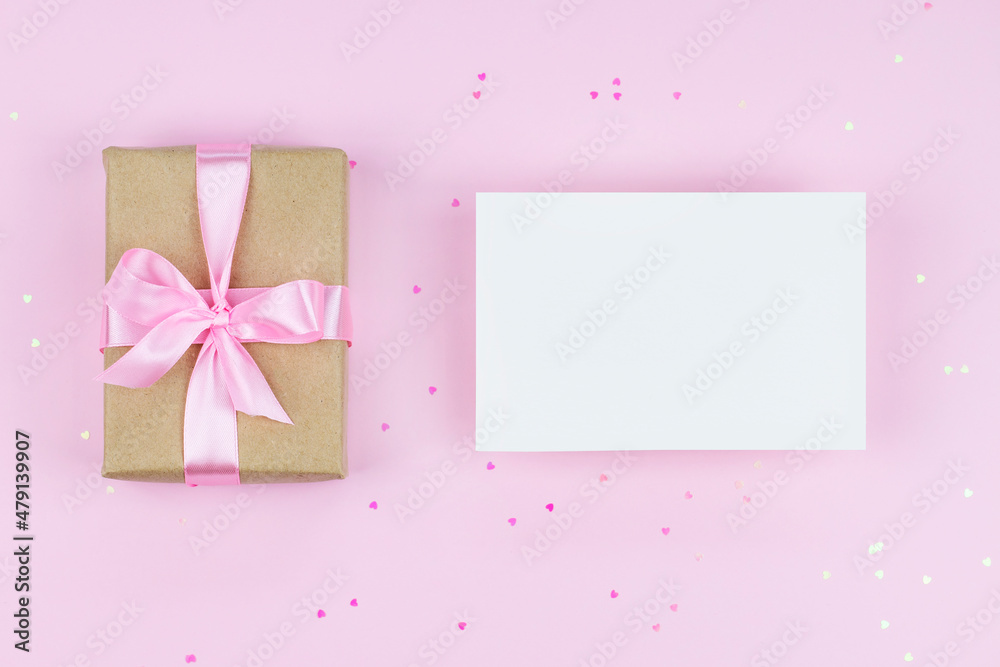 Blank paper card mock up on pink background with present and pink heart shape confetti