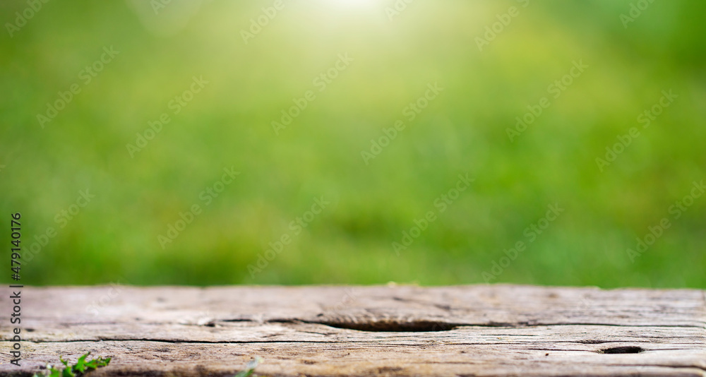 Summer rustic background with wooden table on foreground in sunlight