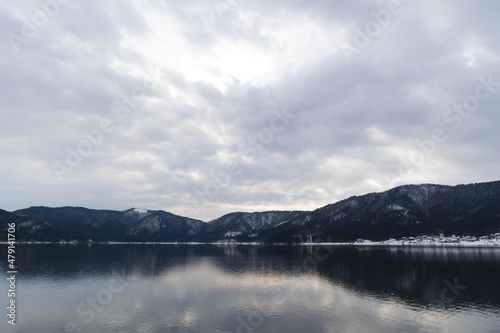 A view of Lake Yogo in Shiga Prefecture in midwinter, with the sky reflecting off the lake surface. © 隼人 岩崎