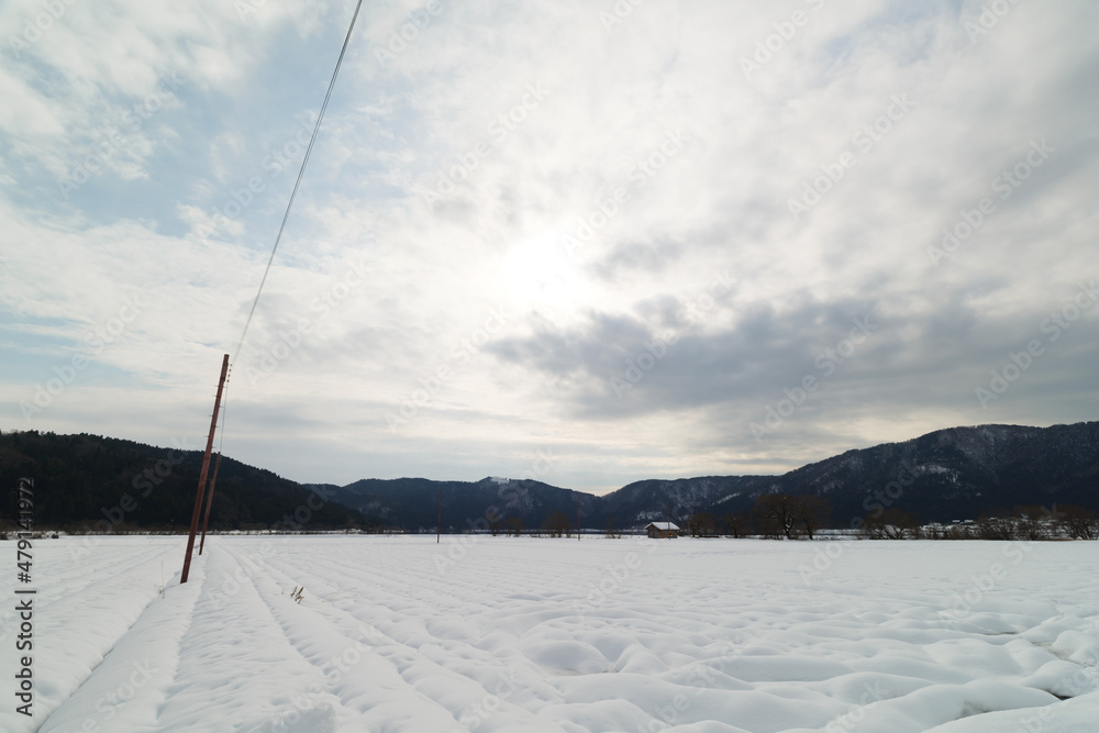 In Shiga Prefecture, Japan, in the middle of winter, a landscape of snow-covered plains and a small hut standing there.