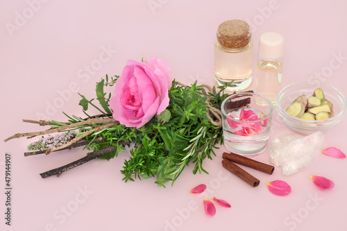 Fotografie, Obraz Witches love potion preparation with rose flower and herb bundle, quartz crystal, spring water, oil bottles, ginger and cinnamon spice on pink background
