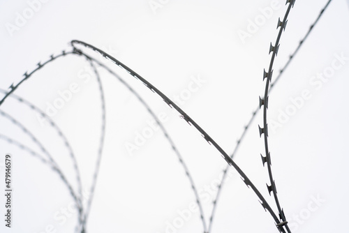 Barbed wire on white cloudy sky background