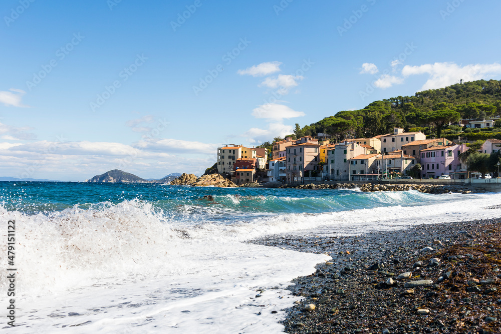 Waves on the beach of the port city of Marciana Marina on the island of Elba in Italy in summer with blue sky