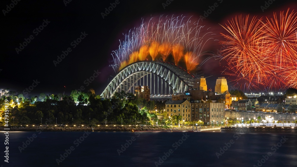 Fototapeta premium city harbour bridge illuminated with vivid colours from NYE New Years Eve fireworks NSW Australia 