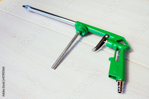 Green air compressor gun. Isolated on a wooden background