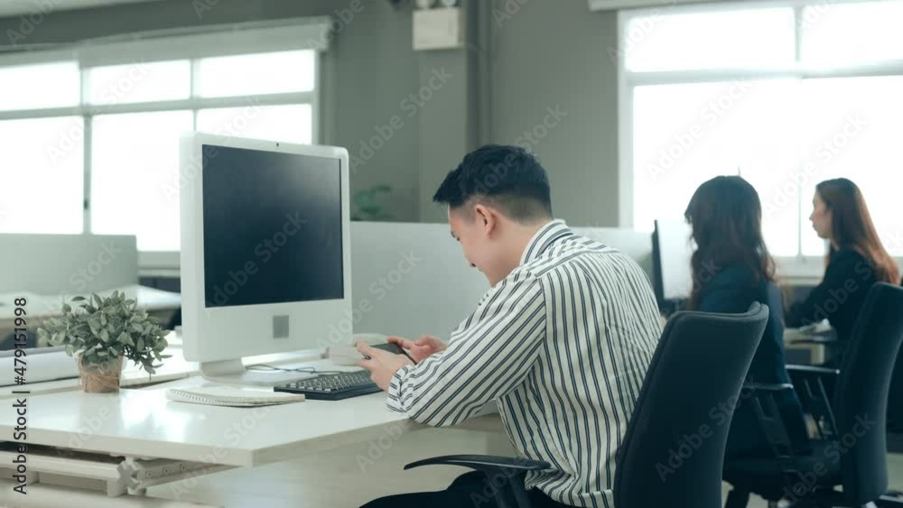 A business man is playing mobile games on his smartphone in office A business man is playing mobile games on his smartphone in office
