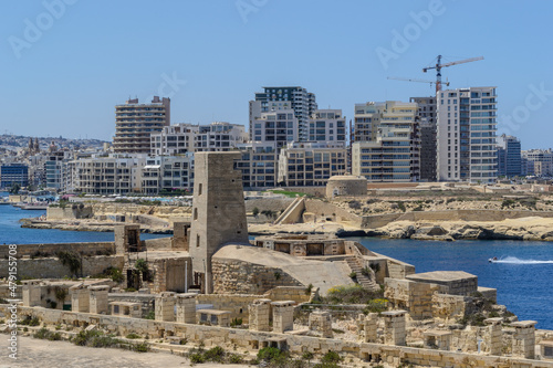 WW2 watchtower on Lower Fort St. Elmo which is part of Fort Saint Elmo in Valletta, Malta. In the background across Marsamxett Harbour is Fort Tigne at the tip of Sliema.