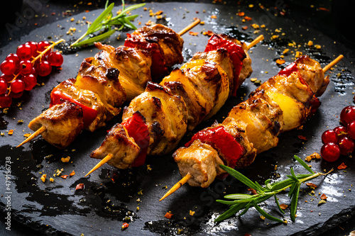 Chicken skewers - grilled meat with fresh vegetables on wooden background
