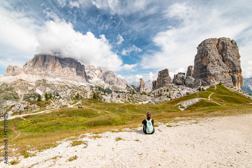 Young sport woman sitting and looking at Cinque Torri and Tofane Tofana di Rozes seen from Rifugio Scoiattoli (refuge). Dolomites, Trentino Alto Adige region, South Tyrol, Italy, Europe. photo