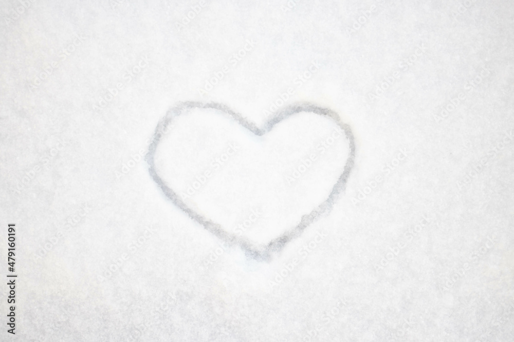 The heart is drawn on fresh snow. The concept of love and romance. Valentine's Day. Winter background The heart is drawn on fresh snow. The concept of love and romance. Valentine's Day. Winter background