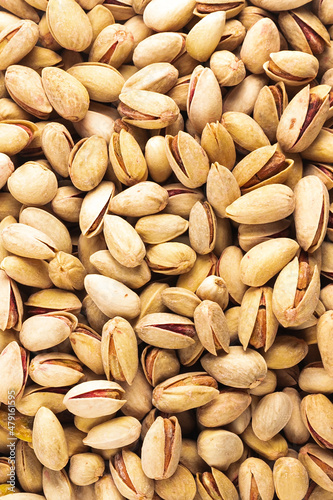 Fresh golden pistachios nuts close up in bulk top view