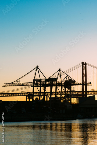 Silhouette of cranes at the Port of Lisbon  Portugal with 25 April Bridge in background