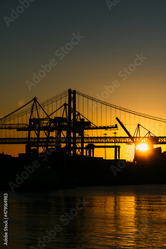 Silhouette of cranes at the Port of Lisbon  Portugal with 25 April Bridge in background