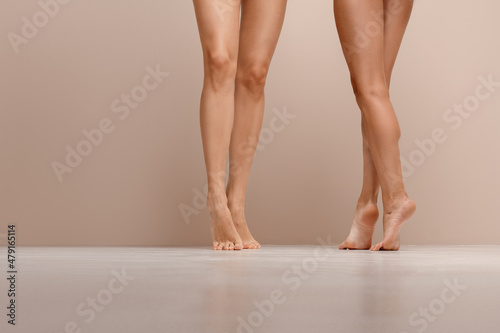 Two pairs of slim female legs on tiptoe
