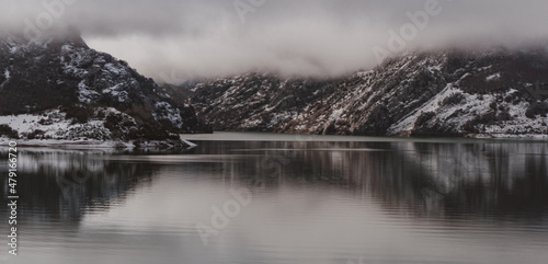 Fog over the mountains in a lake with a water reflection