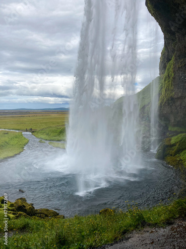 View from behind the falling Water of the Seljalandsfoss Waterfall in Iceland