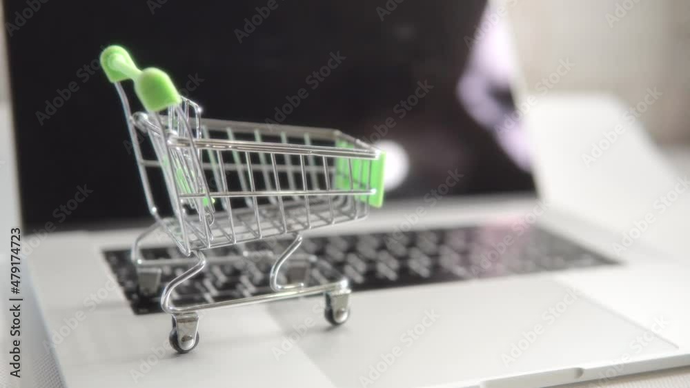 Slow pan shot of a toy green empty metal cart stands on a touchpad, the body of a laptop. Slow pan shot of a toy green empty metal cart stands on a touchpad, the body of a laptop.