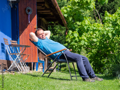 A man enjoying sun on summer day in front of his cottage