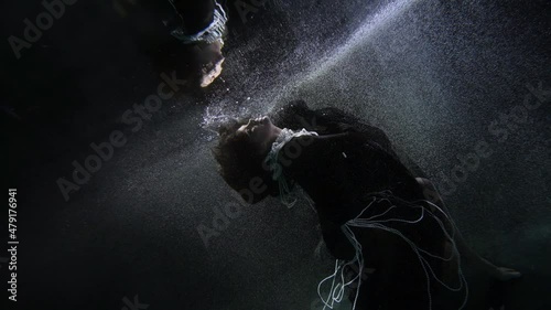 lady in medieval dress is floating underwater and praying, atoning for sin, begging for mercy