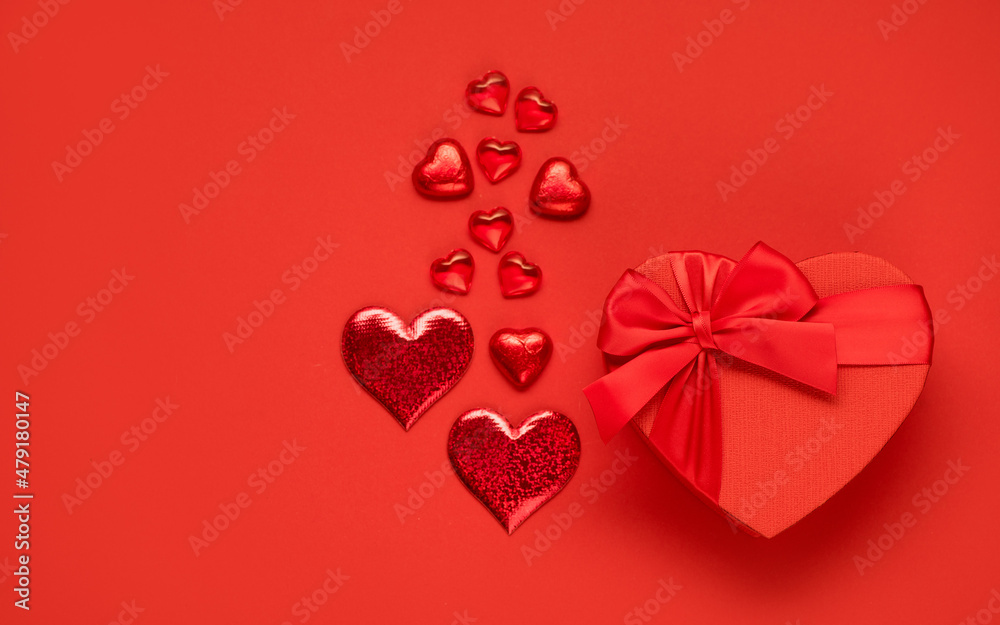 Valentine's day or Wedding romantic concept. Red festive box and chocolates on red background.Top view, flat lay, copy space