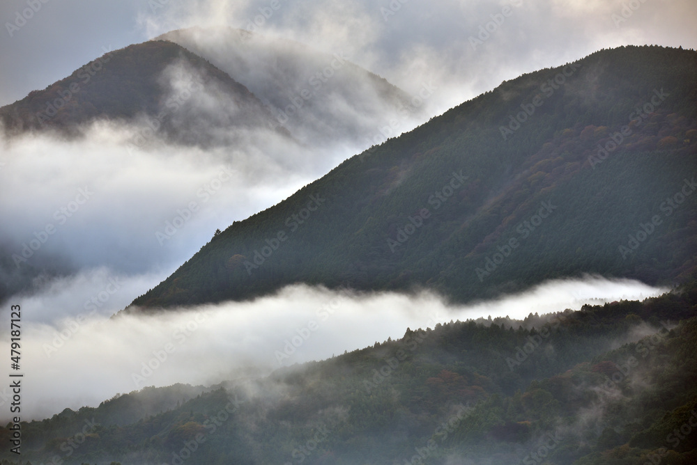 雲と霧が広がる山の抽象的イメージ