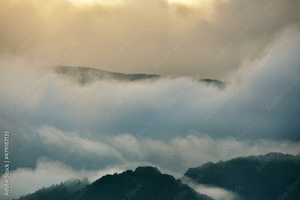 雲と霧が広がる山の抽象的イメージ