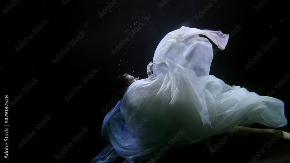 woman is sinking and swimming up inside depth of dark sea or river woman is sinking and swimming up inside depth of dark sea or river